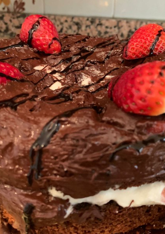 Una foto de Bizcocho de Colacao, nata, fresas y cobertura de chocolate