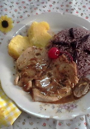 Una foto de Lechón a la hierbabuena con limón y guarnición de arroz al olivo