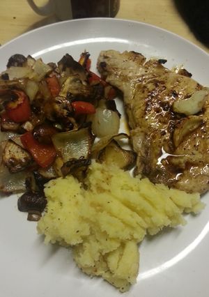 A picture of Pork chop, mashed potato and roasted veg.