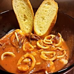 A picture of Calamari Stew with Garlic Toast.