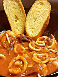 A picture of Calamari Stew with Garlic Toast.