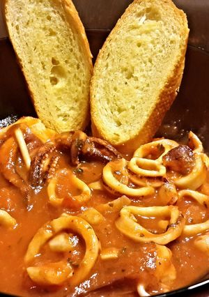 A picture of Calamari Stew with Garlic Toast.