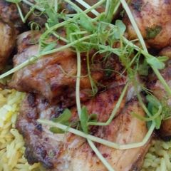 A picture of Lemon and herb chicken on a bed of rice.