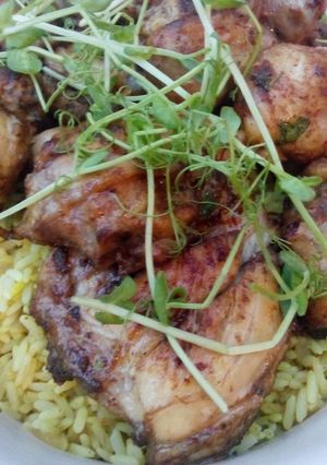 A picture of Lemon and herb chicken on a bed of rice.