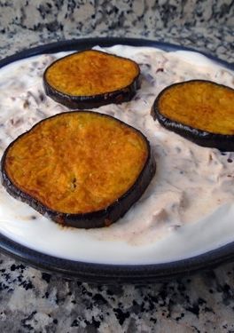 Una foto de Dahi baingan o berenjenas con crema de yogur especiado