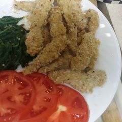 A picture of Turkey Cutlets with sautéed spinach and tomato slices.