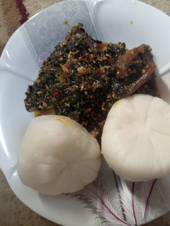 A picture of Tuwon Rice with ugwu and water leaf soup.