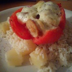 A picture of Stuffed tomato with sausage and boccocini on coconut and pineapple rice.