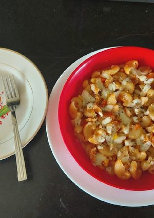 A picture of Chicken macaroni cheese with red and white sauce.