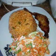 A picture of Jollof rice,fried chicken, Cole slaw.