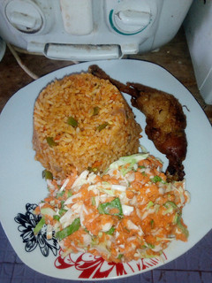 A picture of Jollof rice,fried chicken, Cole slaw.