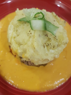 A picture of Mince and creamy mashed potatoe with an orange, squash sauce.