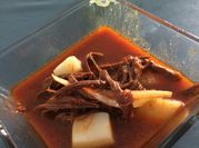 Una foto de carne deshebrada con cebolla y tomate