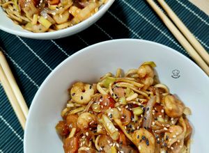 Una foto de Udon noodles de gambas y verduras con salsa de pato Pekín