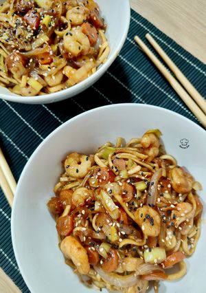 Una foto de Udon noodles de gambas y verduras con salsa de pato Pekín