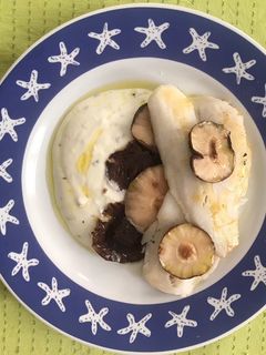 Una foto de Merluza a la plancha con salsa blanca y setas chinas