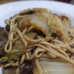 A picture of Marinaded steak strips with noodles.