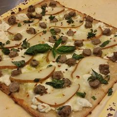 A picture of Flatbread pizzette w/ Sausage, Pear, Goat Cheese an Mozzarella.