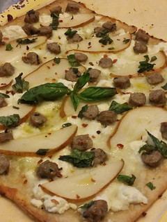 A picture of Flatbread pizzette w/ Sausage, Pear, Goat Cheese an Mozzarella.