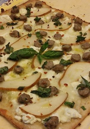 A picture of Flatbread pizzette w/ Sausage, Pear, Goat Cheese an Mozzarella.