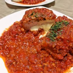 A picture of Herb Breaded Chicken Breast Served in Tomato Sauce.