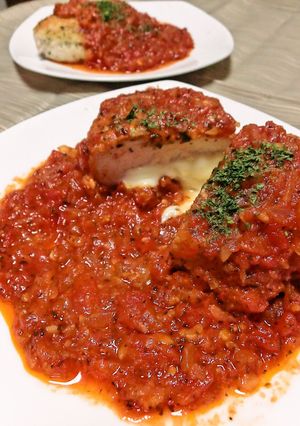 A picture of Herb Breaded Chicken Breast Served in Tomato Sauce.