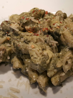 A picture of Spinach & Artichoke dip pasta with grilled chicken.