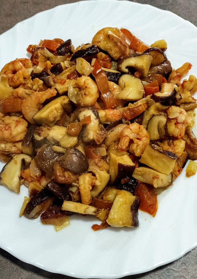 Una foto de Colas de carabinero peladas con setas shiitake y pimiento rojo