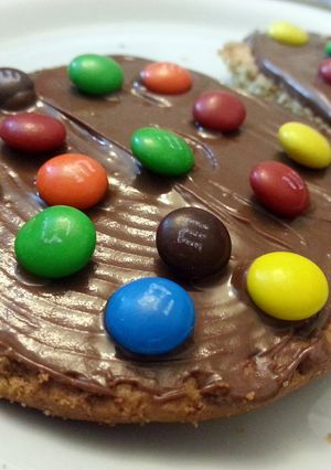 A picture of Biscuits with nutella and m&m's topping.
