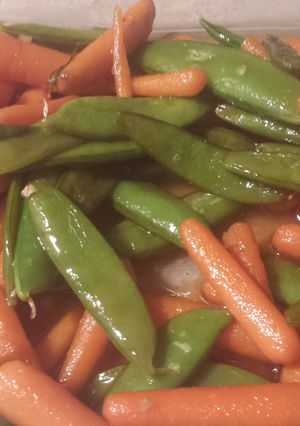 A picture of Asian style sugar snap peas and baby carrots.