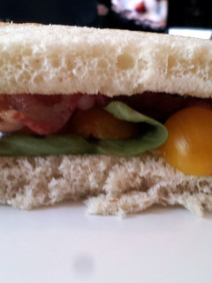A picture of Bacon and Basil Sandwich with Goat Cheese Brie and Golden Tomatoes.