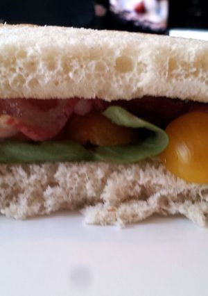 A picture of Bacon and Basil Sandwich with Goat Cheese Brie and Golden Tomatoes.