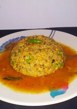 A picture of Daliya khichdi with tomato rasam.