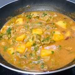 A picture of Goat meat stew with some potatoes.