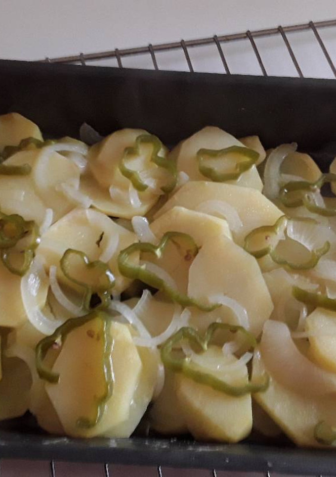 Una foto de Patatas al horno con cebolleta y aros de pimiento