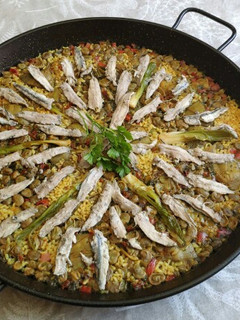 Una foto de Paella huertana de boquerones, habas, alcachofa y ajos tiernos