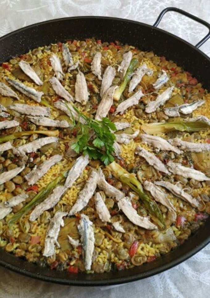 Una foto de Paella huertana de boquerones, habas, alcachofa y ajos tiernos
