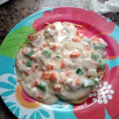 A picture of homemade veggie white sauce over chicken and spaghetti.
