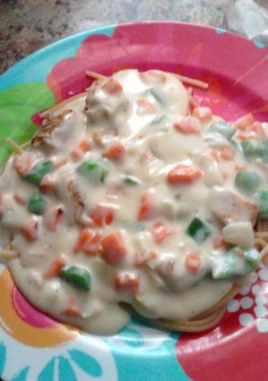 A picture of homemade veggie white sauce over chicken and spaghetti.