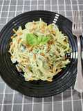 Spaghetti a la crema de burrata y albahaca con berenjena frita y piñones