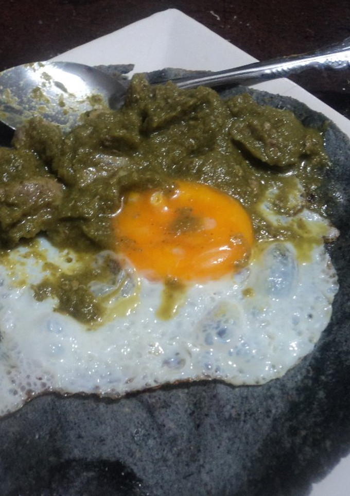 Una foto de Huevo ranchero de año nuevo, con carne de cerdo o pierna en salsa verde y frijoles fritos