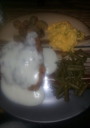A picture of Down south chicken fried steak with cracked pepper white gravy.