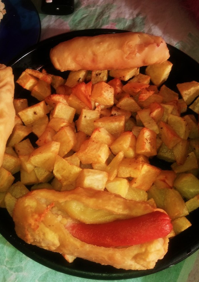 Una foto de Salchichas con puré envueltos. Con masa casera y papas al horno