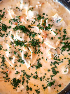 Una foto de Raviolones (al disco) con salsa de crema y camarones