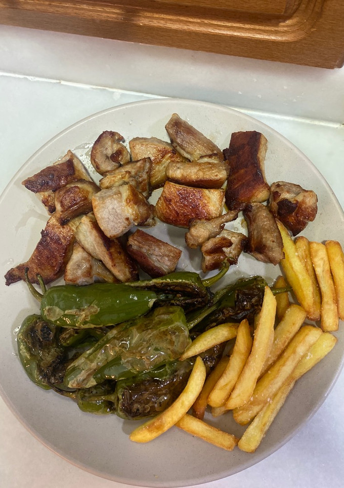 Una foto de Secreto ibérico con patatas fritas y pimientos de padrón