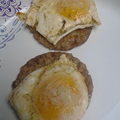 A picture of Eggs over sausage.