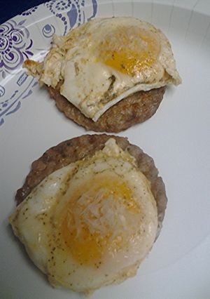 A picture of Eggs over sausage.