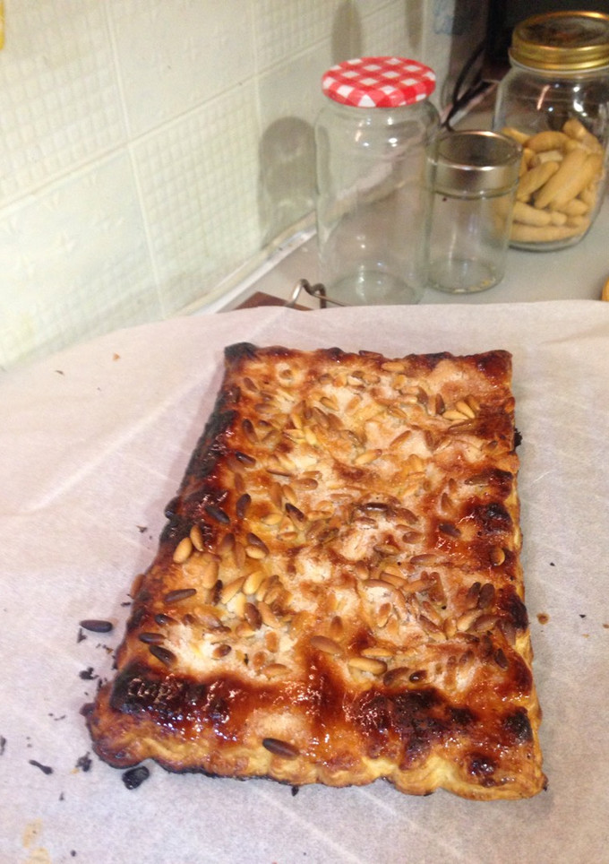 Una foto de Coca de piñones rellena de natillas