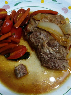 Una foto de Bondiola con salsa y vegetales