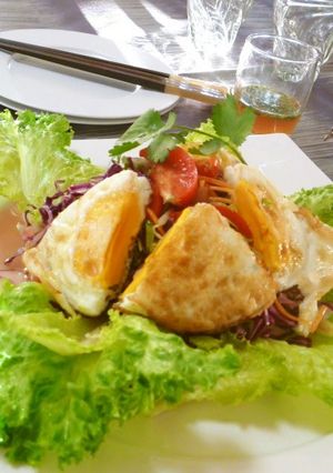 A picture of Thai-style Salad with Vegetables and a Sunny-side Up.